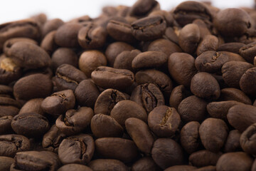 Brown roasted coffee beans isolated on white background.