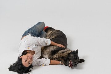 pretty dark long hair smiling woman with dog in photo studio on white background. High quality photo