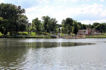 View of the pond and pier in the city Park on a Sunny summer day