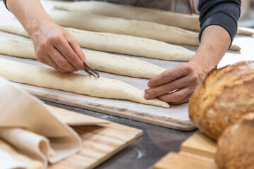 Making craft bread at the bakery. Close-up of a baker and bread, blurred background