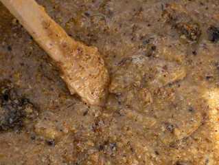 The texture of a thick mass of bee honey with a wooden spoon.