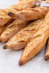 Freshly baked French baguettes lie on a light-colored surface. Rustic handicraft bread, handmade