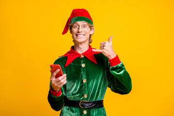 Photo of guy hold smartphone hand show phone toothy smile wear elf velvet green costume headwear...