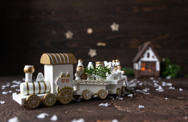 Fototapeta na wymiar White festive Christmas wood train and house with fir branches in backdrop. Winter holidays concept. Christmas greeting card.