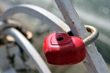 Traditional wedding locks for good luck hang on the railing of the bridge in the city Park on a Sunny summer day