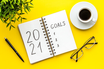 Inspiration concept - New Years goals written in notebook on a table, flat lay