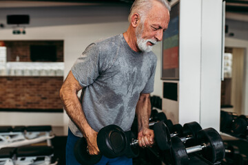 Fototapeta na wymiar Senior man exercising at gym.