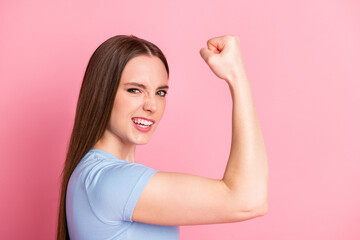 Photo portrait profile of strong feisty woman flexing biceps isolated on pastel pink colored background