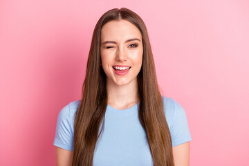 Photo portrait of winking girl isolated on pastel pink colored background