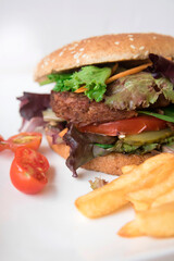 A vegan burger with vegetables and tomato

