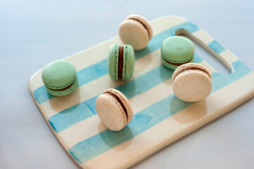 
light blue and natural macarons on scratched ceramic table on white background