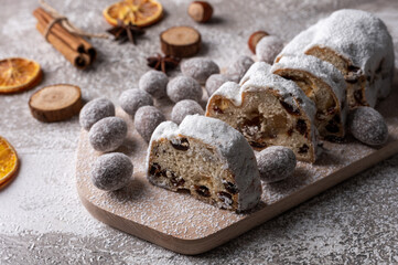 Christmas stollen on wooden board with fruits and nuts. Traditional german cake.Concept for postcard, holiday greeting.