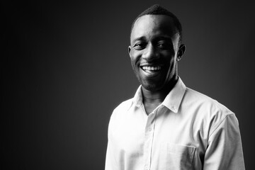 Portrait of young African businessman against gray background