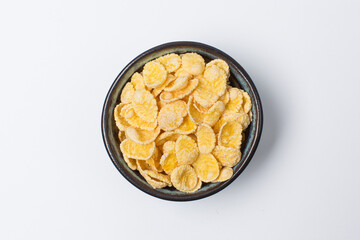 Corn flakes in bowl on white background