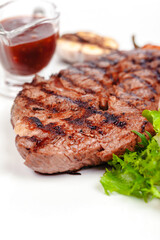 Grilled steak with vegetables and sauce on white background