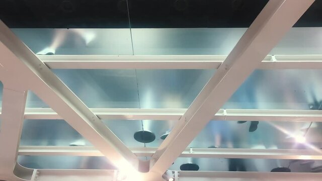 bottom view of people walking on a transparent opaque glass floor
