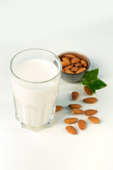 Glass of milk and almonds in studio