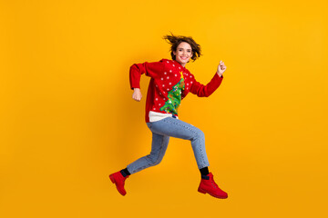 Full size profile side photo of cheerful girl jump run x-mas tradition discounts wear christmas tree theme decor sweater pullover denim jeans isolated bright shine color background