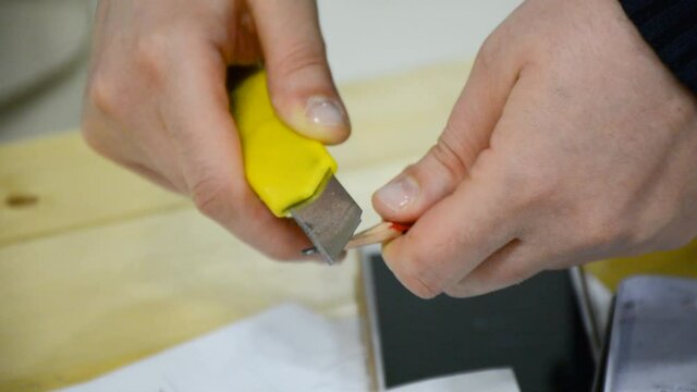 hands of a person sharpening a pencil
