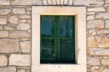 Fototapeta na wymiar Traditional Mediterranean house with stone facade and wooden window.