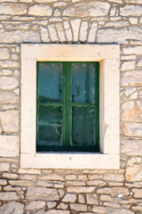 Fototapeta na wymiar Traditional Mediterranean house with stone facade and wooden window.