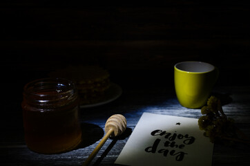 Still life with cup of coffee and waffles on the wooden background. Photo taken in low light key.