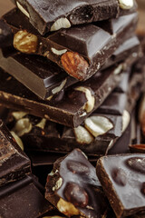 Stack of chocolate slices with mint leaf on a wooden table.Assortment of fine chocolates in white, dark, and milk chocolate. Sweet food photo concept.