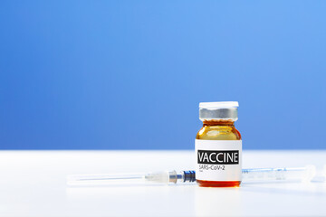 Sars-cov-2 vaccine vial and syringe on white table