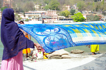 Women unroll saris on the banks of the Ganges, India