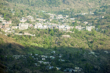 Fototapeta na wymiar Indian Himalayas, mountain slopes, hillside village, tree houses