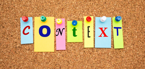 Multicolor notes with letters pinned on a cork notice board.