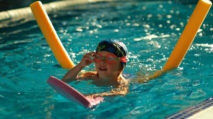 Future champion. Swimming training for the little champion. Little cute boy strengthens his health by swimming in the pool.
