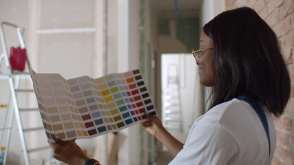 Attractive young african woman choosing new colors for home renovation