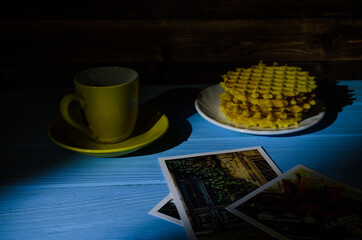 Fototapeta na wymiar Still life with cup of coffee and waffles on the wooden background. Photo taken in low light key.