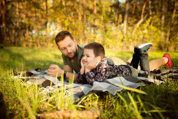 Naklejka na ściany i meble Weekend. Father and son walking and having fun in autumn forest, look happy and sincere. Laughting, playing, having good time together. Concept of family, happiness, holidays, childhood, lifestyle.