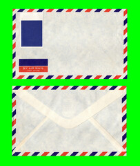 A nice vintage airmail letter envelope, front and back, with a blank stamp, stripes on every side, and lots of copy space. Isolated on a green background.
