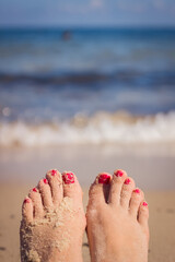 Woman feet closeup of girl relaxing on beach on sunbed enjoying sun on sunny summer day.