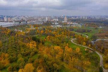 Beautiful winding paths in the autumn park! Loshtsky Park, Minsk! Bright colors of autumn! Orange and yellow alleys! City in the background.