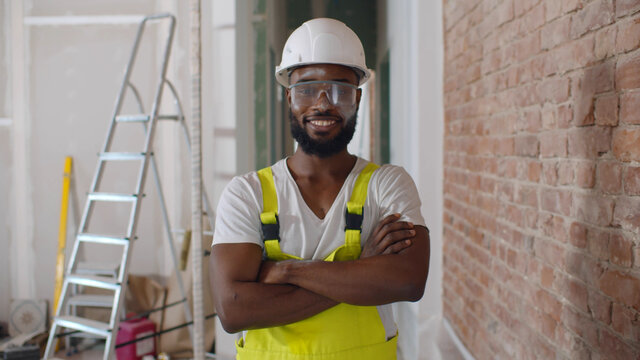 Renovation handyman with protective glasses and helmet looking at camera