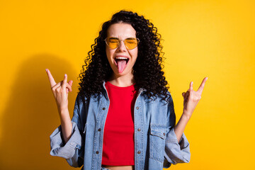 Photo of girl stick out tongue eyes closed show horns wear red t-shirt jacket isolated yellow color...