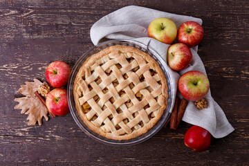 Traditional American Thanks Giving pie with whole organic apples, cinnamon sticks on wooden table....