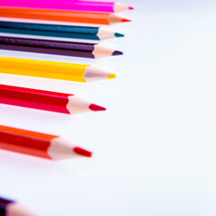 Colored pencils on a white background, copy space, isolated, close-up, side view