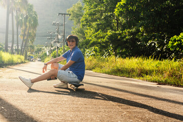 Happy young woman sitting on wave-board or skateboard and using phone to listen music © Parviza