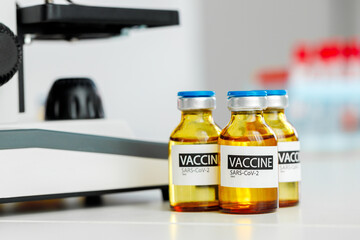 Vial of Covid-19 coronavirus vaccine on table in medical lab
