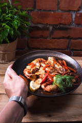 Delicious fried langoustines in sauce on a black plate, prepared in an Asian style. Fast and ready meal concept