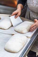 Making craft bread at the bakery. Close-up of a baker and bread, blurred background
