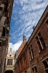 Fototapeta na wymiar Brugge upward diagonal view of old buildings and cloudy blue sky