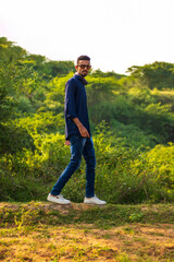 Portrait of young indian man, wearing blue shirt and denim jeans