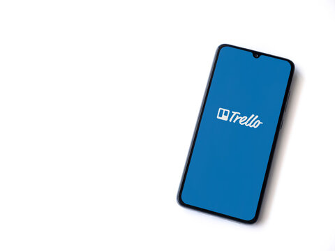 Lod, Israel - July 8, 2020: Trello app launch screen with logo on the display of a black mobile smartphone isolated on white background. Top view flat lay with copy space.