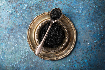 Delicious black caviar in vintage silver bowl with spoon